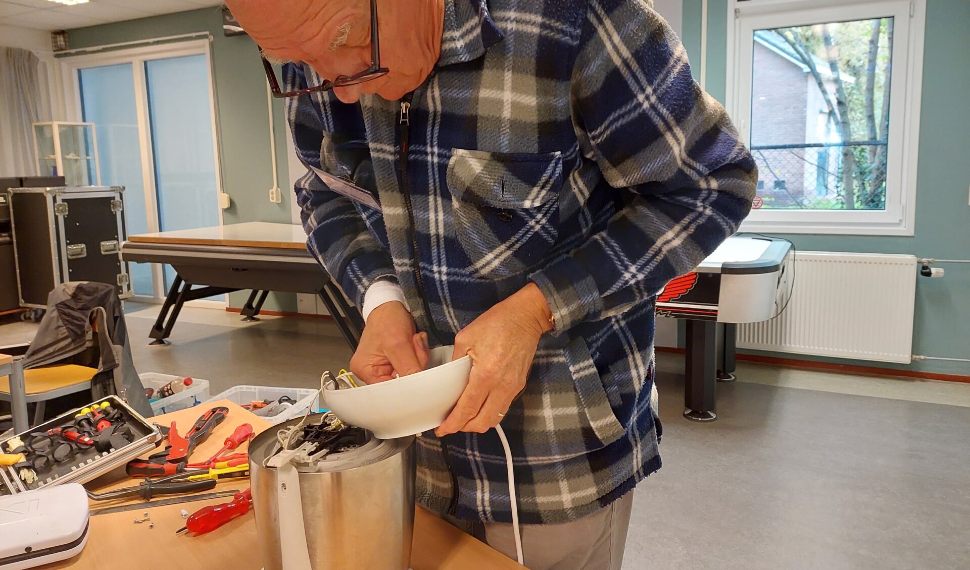 Vrijwilliger van Repair Café Veenendaal repareert een apparaat