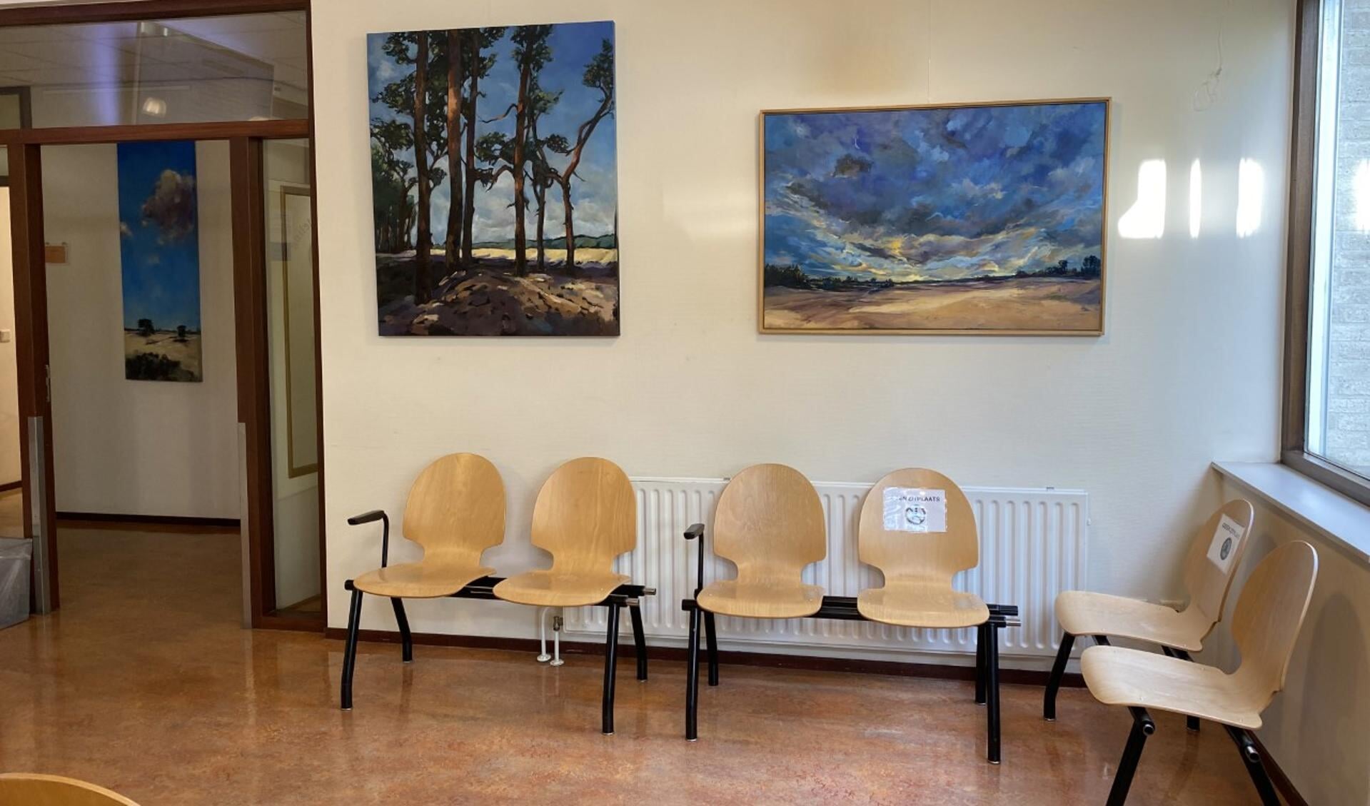 De wachtkamer met enkele schilderijen van Karin Alberts.