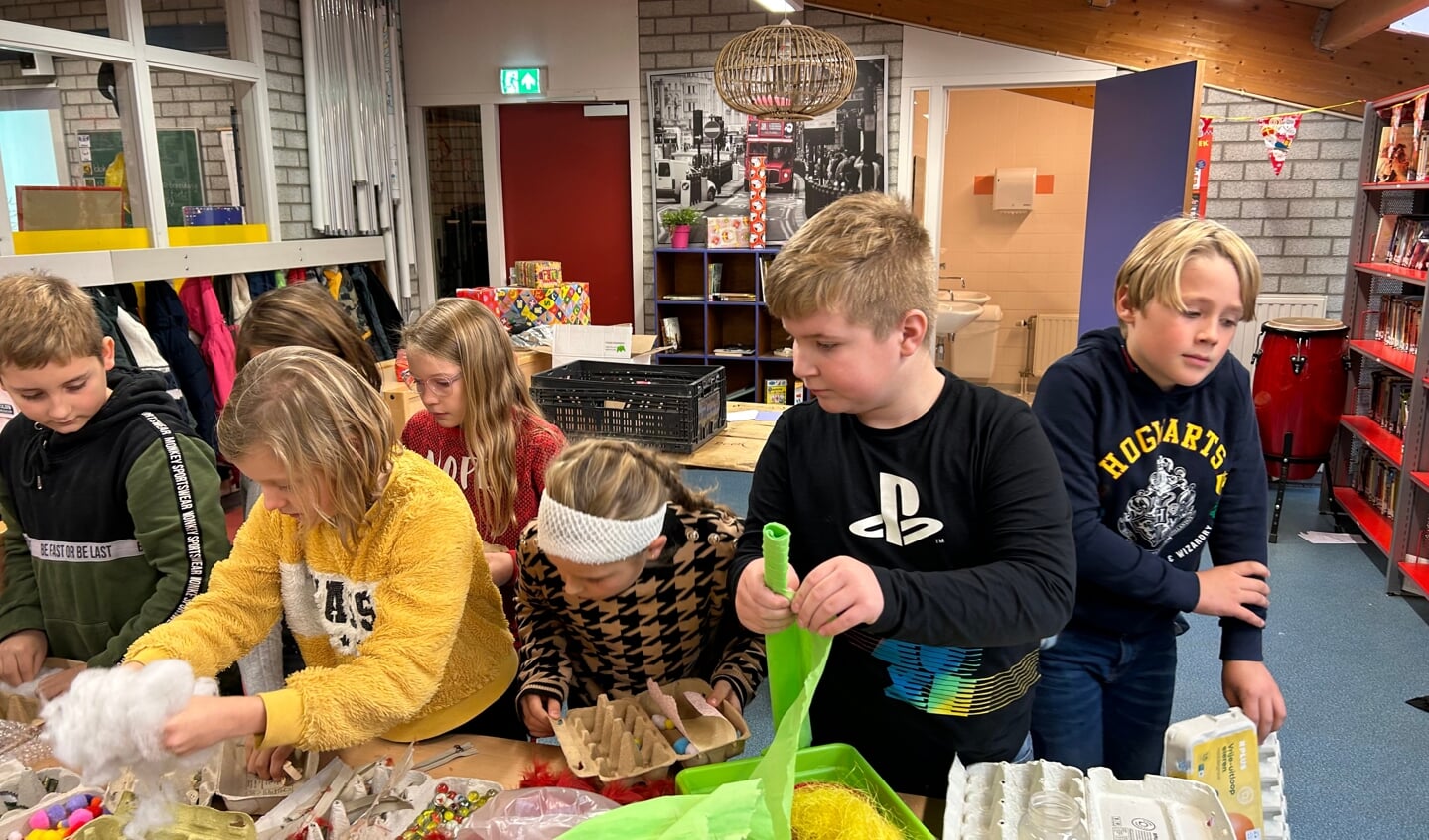 Leerlingen kiezen zorgvuldig hun materialen om hun kunstwerk zo mooi mogelijk te maken.