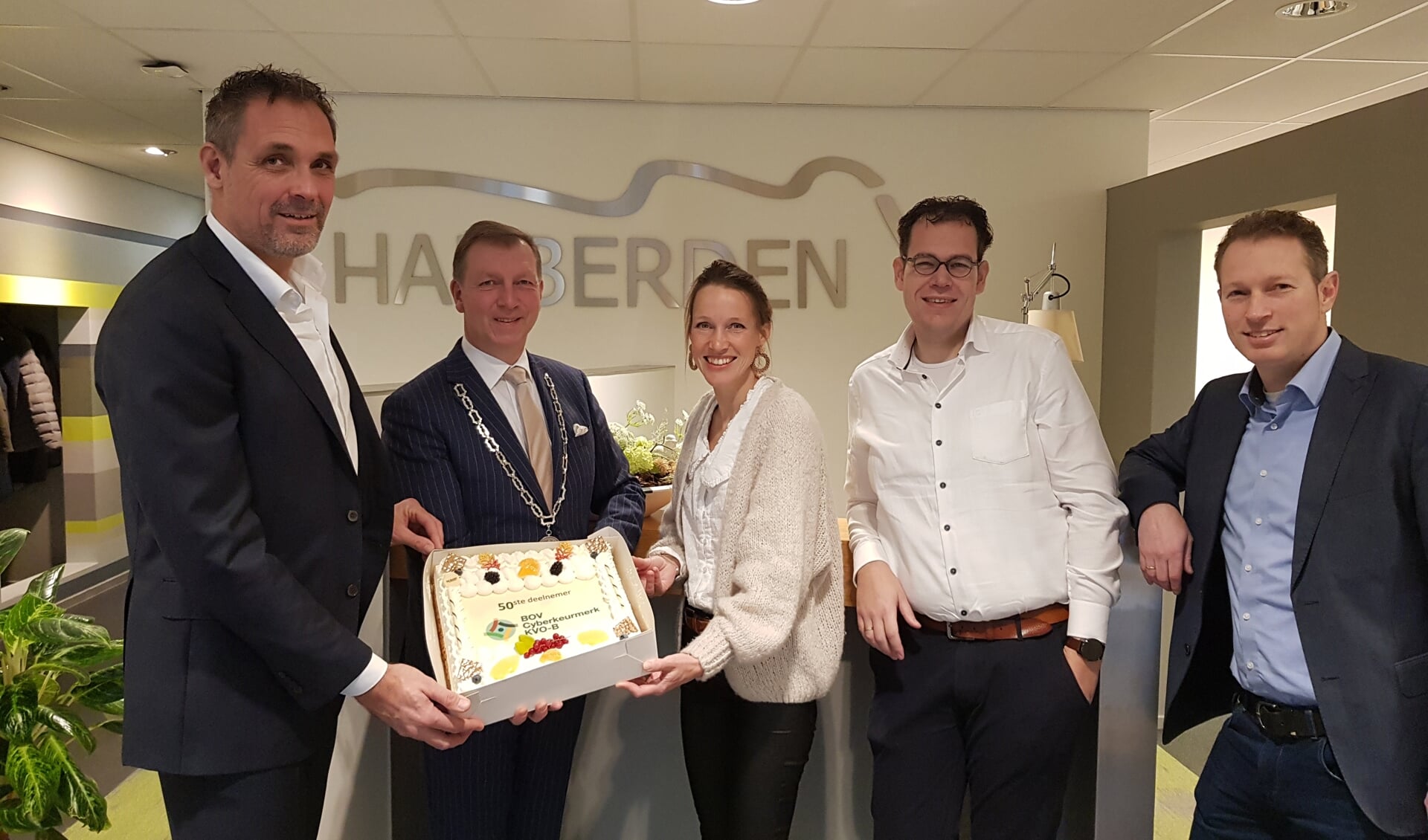 Hans van Veldhuizen (links) neemt de taart in ontvangst van Gert-Jan Kats, onder het toeziend oog van Willemijn van de Lagemaat (Lupasafe), Pieter Willemsen (Hupra ICT) en Gerrit Valkenburg (BOV).