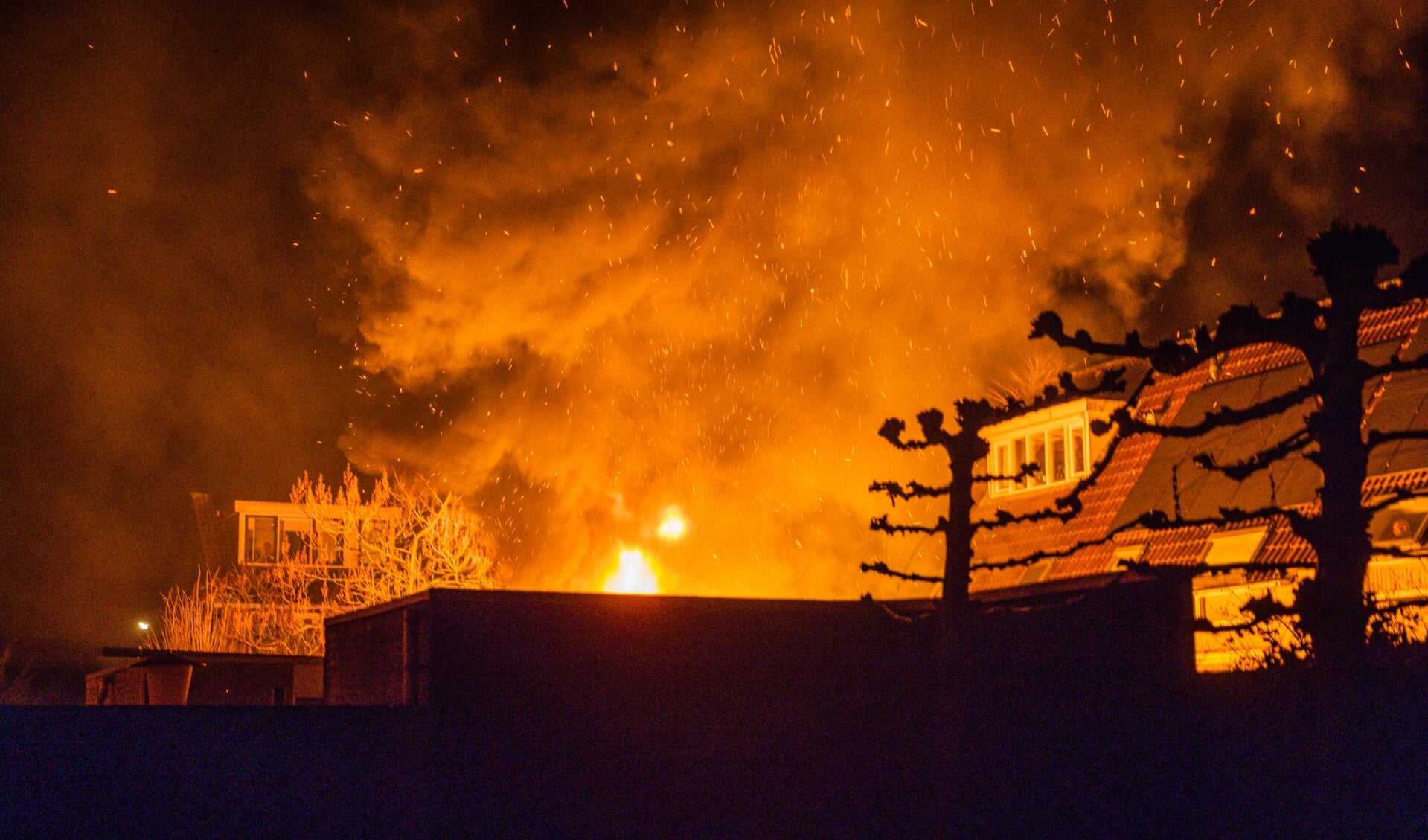 De vlammen verlichten de woningen aan de Weideweg in Austerlitz.