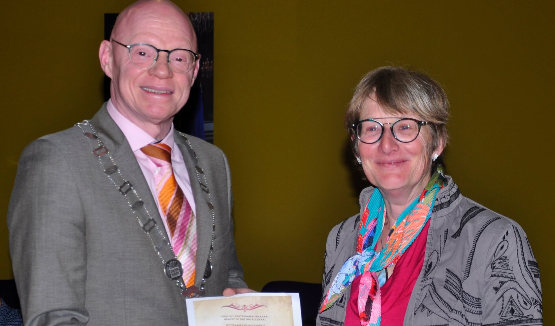 Burgemeester ontvangt het gedicht voor de dorpsdichter  uit handen van Anja Tekelenburg