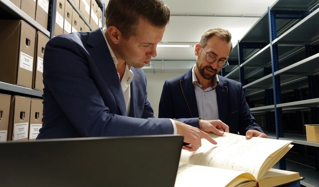 Streekarchivaris Rudolf Bosch en beleidsmedewerker collecties Peter Bakker kijken samen naar de staat van de bevolkingsregisters in Harderwijk