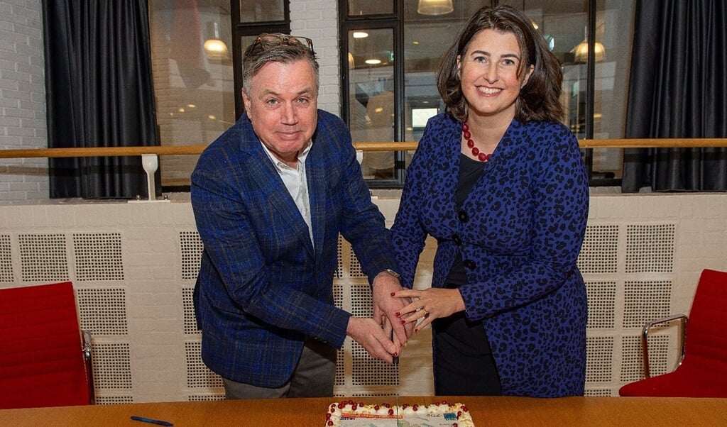 Wethouder Barbara de Reijke en Jan Huybregts van Projectontwikkeling Grondbedrijf Zuidpark vieren de gemaakte afspraken voor de bouw met taart.