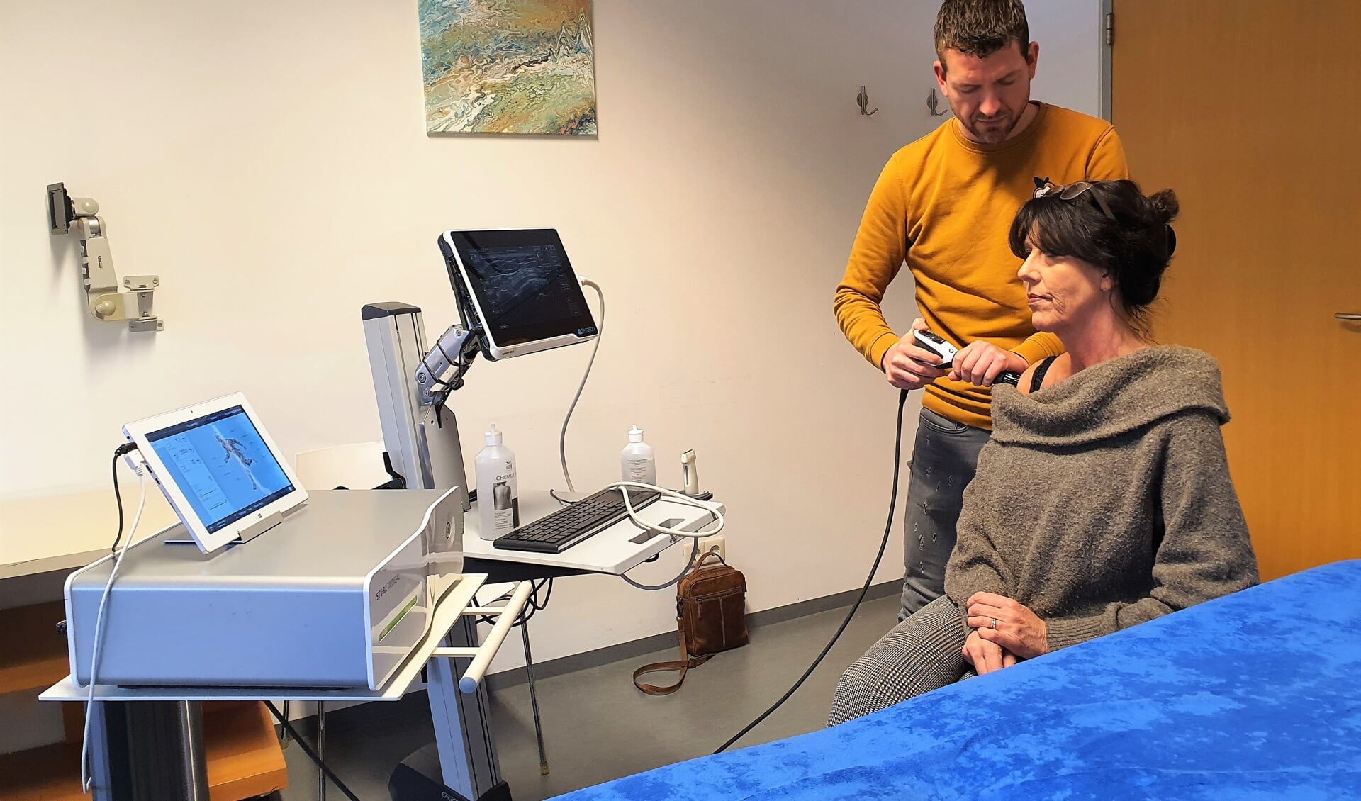 Timon van Ginkel, fysiotherapeut bij Fytalis, behandelt een patiënt met shockwavetherapie. 