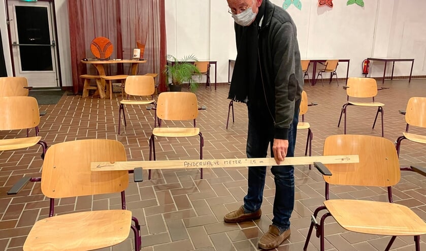 Een koorlid controleert de gepaste afstand