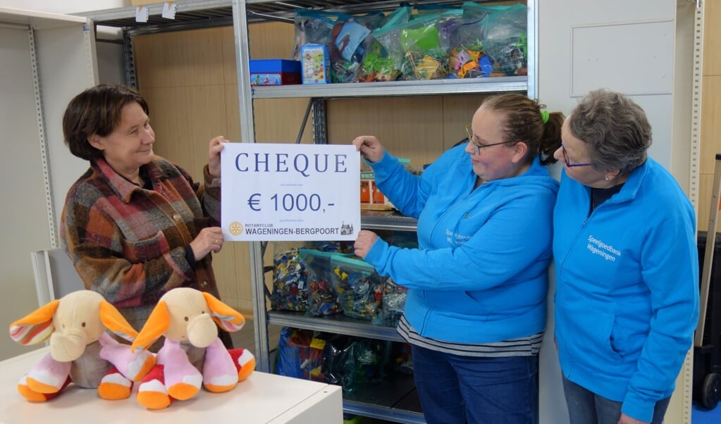 Marjan Hoogsteen, voorzitter van Rotaryclub Wageningen-Bergpoort overhandigt een cheque van 1000 Euro aan Ellie en Miranda van de Weerd van de Speelgoedbank.