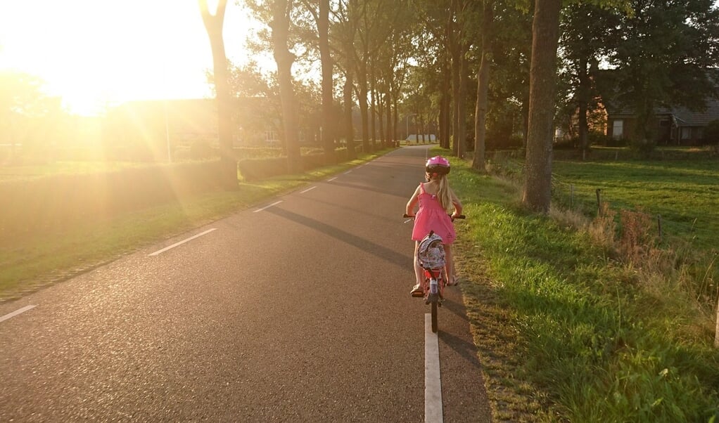 Kind op fiets op weg naar school.