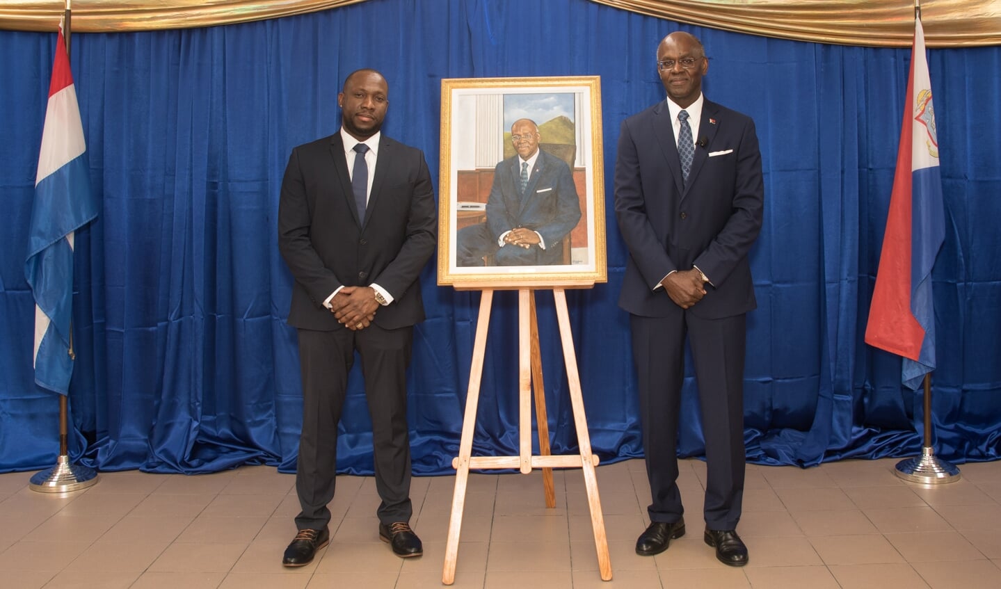 Alfredo Doornkamp (links) met gouverneur Eugene Holiday van St. Maarten en het geschilderde portret.