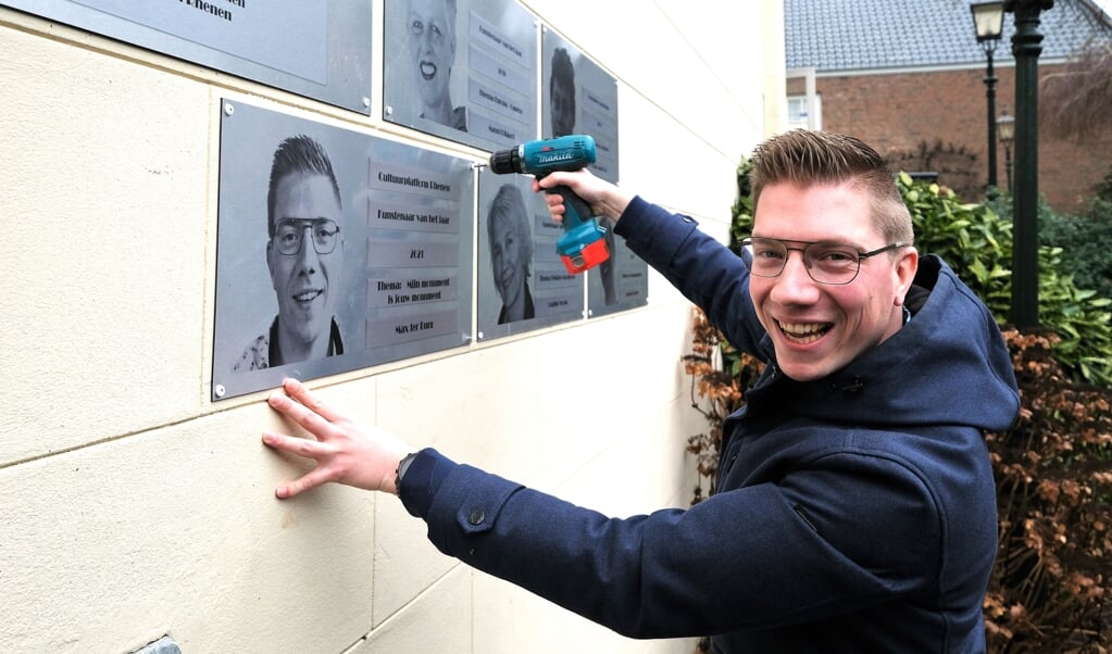 Max ter Burg schroeft zelf zijn plaquette vast aan de buitenmuur van Stadsmuseum Rhenen, naast de andere prijswinnaars.