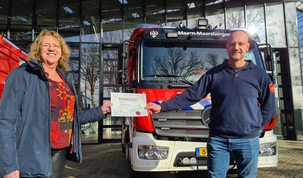Francien Goddijn, voorzitter van de SVRM, neemt de donatie in ontvangst van Geurt Versteeg, voorzitter van de Vereniging Brandweer Maarn-Maarsbergen