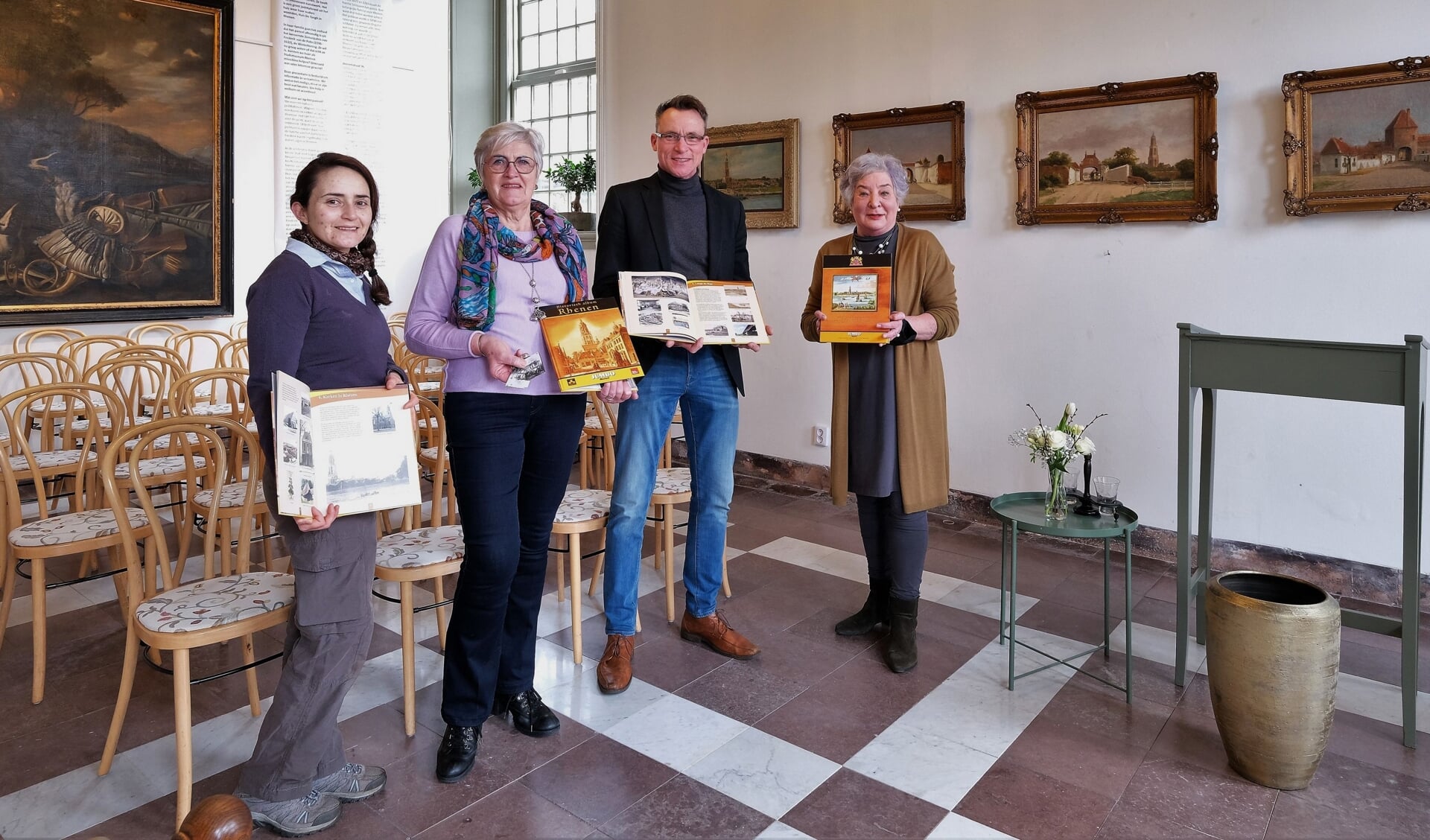Vrijwilligers van het stadsmuseum tonen de plaatjesalbums samen met Cornelis Mostert.