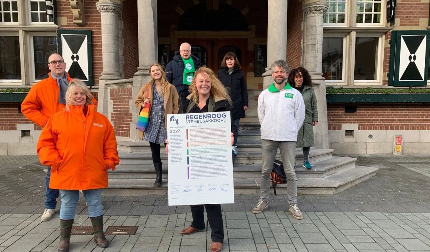 Na de ondetekening het fotomoment: de vrouw met het bord is Laura van Nieuwenhuijze, voorzitter van COC Midden-Nederland.