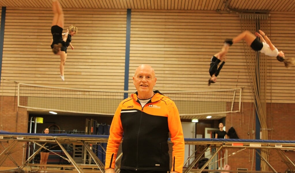 Hans van Zetten met op de achtergrond de trampolinespringers van Sparta Ermelo.