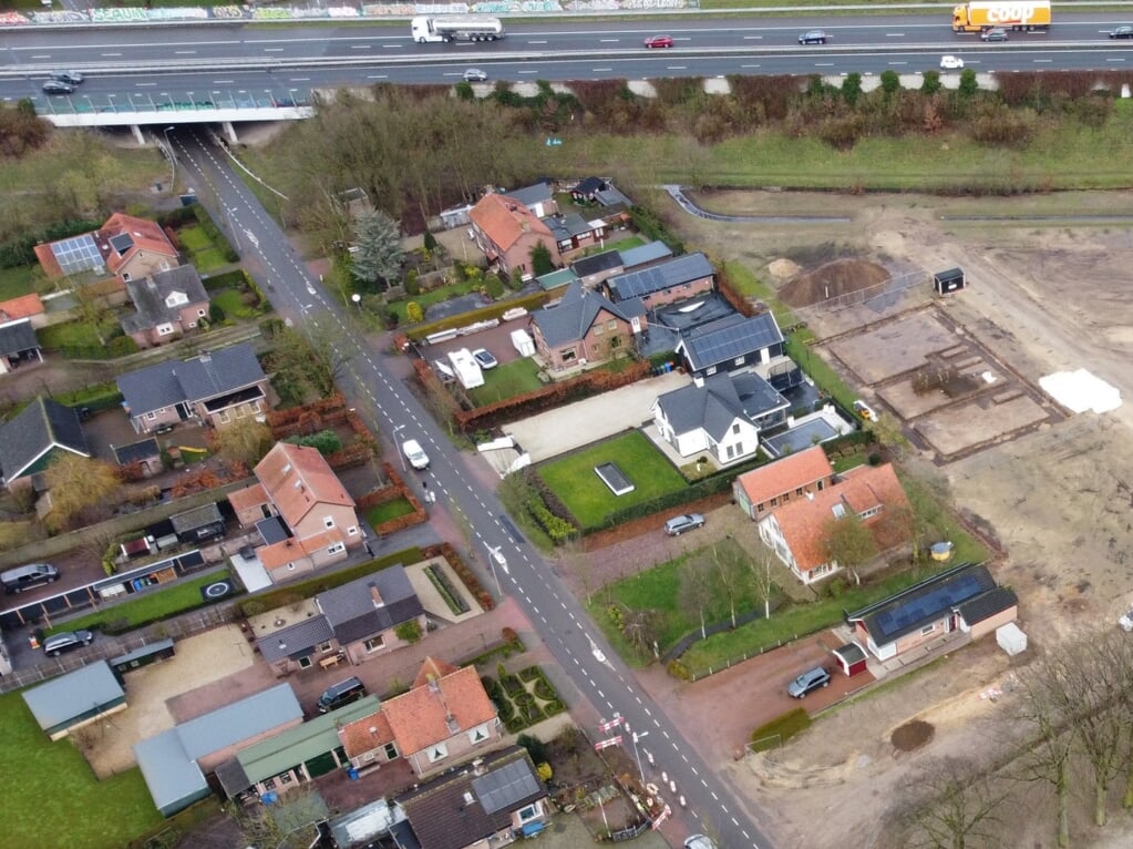 De Tolnegenweg in Stroe met bovenaan de A1. Links van de dwars staande twee-onder-een-kapwoning met het oranje dak (aan de linker kant van de foto)  wordt een nieuwe vrijstaande woning gebouwd.  
