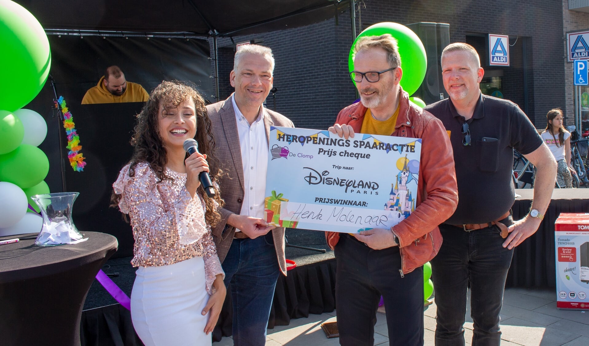 Wethouder Catsburg staat links van de winnaar. Rechts staat de voorzitter van de winkeliersvereniging, bakker Vonk.