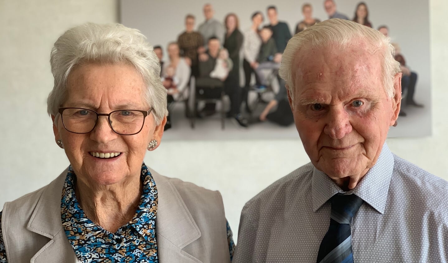 Echtpaar Kamminga-Van de Weerd is 70 jaar getrouwd. Op de achtergrond een foto met kinderen, kleinkinderen en achterkleinkinderen