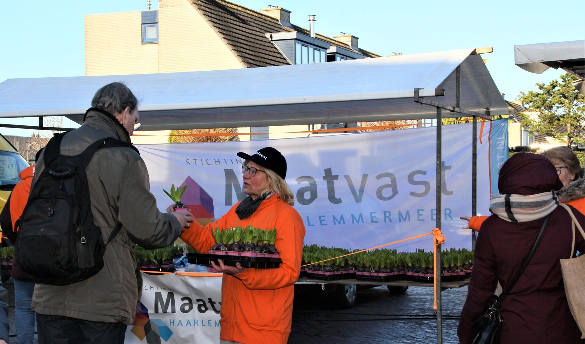 Een medewerkster van Maatvast op archief tijdens het uitdelen van plantjes.