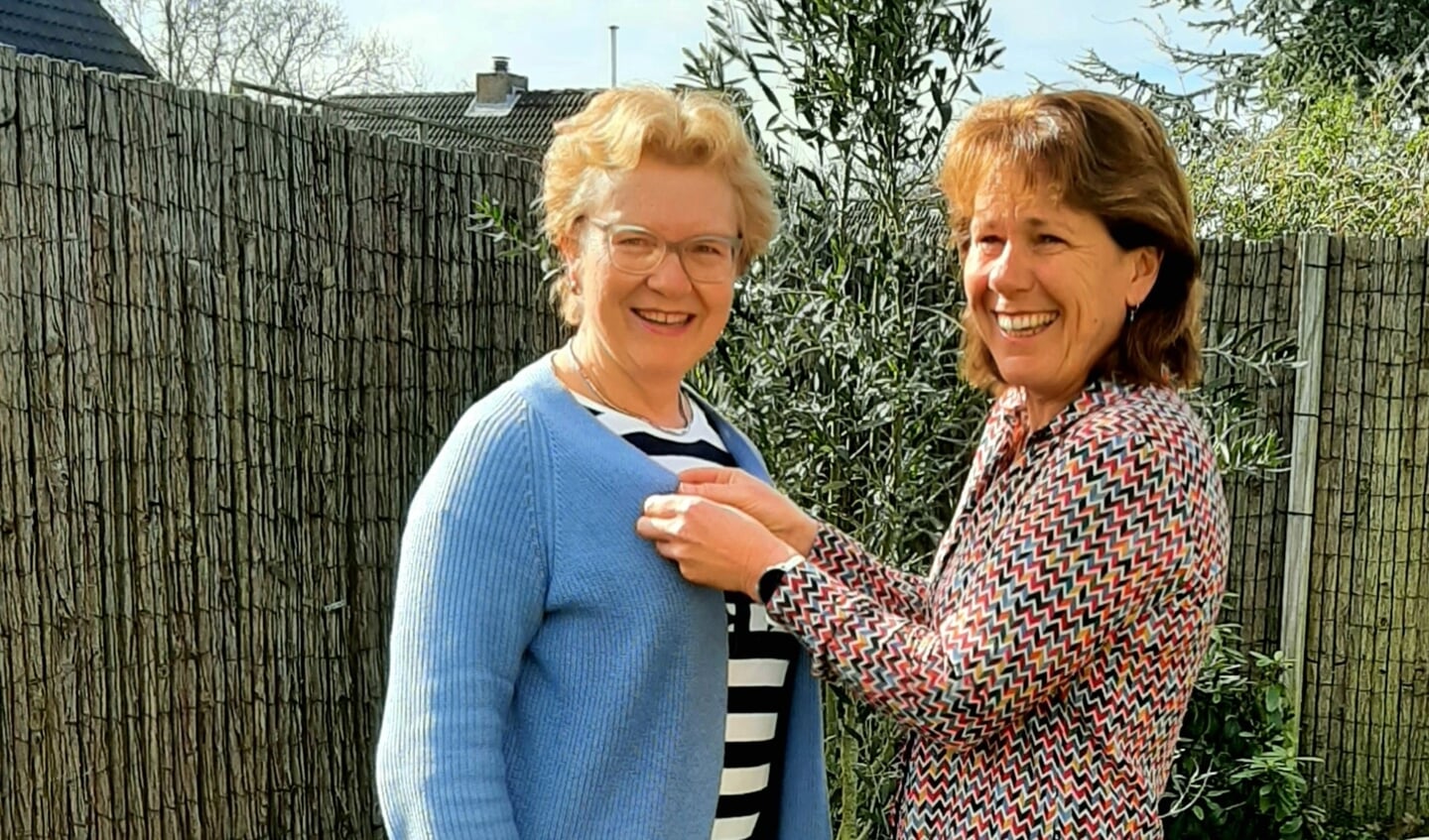 Herbalife Nutrition coach Connie Huibregtse spelt bij de trotse Elly Korevaar haar 20 jarig haar jubileum speldje op