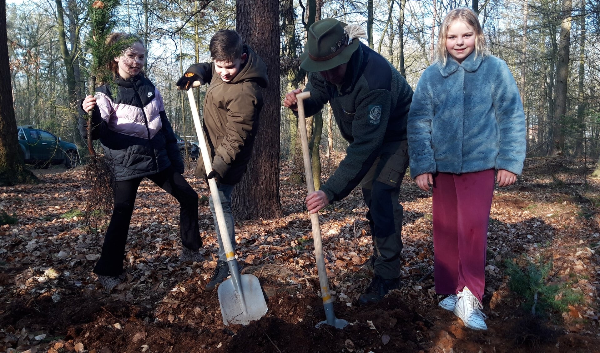 Leerlingen helpen de boswachter bij het aanplanten van bomen