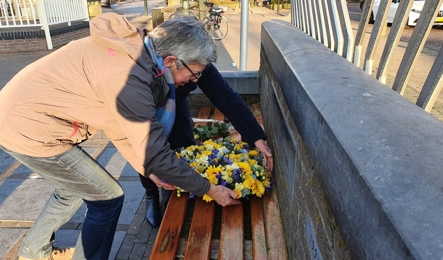 De drie bestuursleden van Stichting voor Vrede en Vrijheid  legden een bloemenkrans bij de  herdenkingsbank op het Plein in het Oude Dorp 