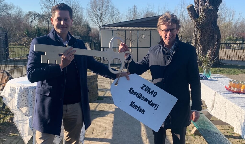 Wethouder Jan Overweg draagt de sleutel van Speelboerderij Houten over aan ZOMO directeur Merijn Vos.