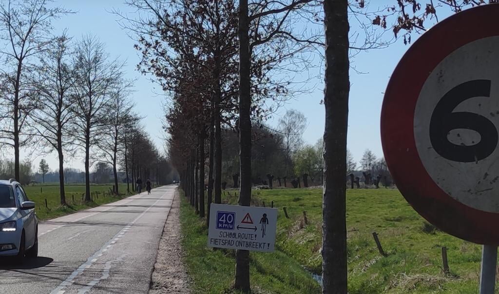 Geïmproviseerd bord in de berm van de Bovenwijkerweg om aandacht te vragen voor de situatie van fietsende scholieren.
