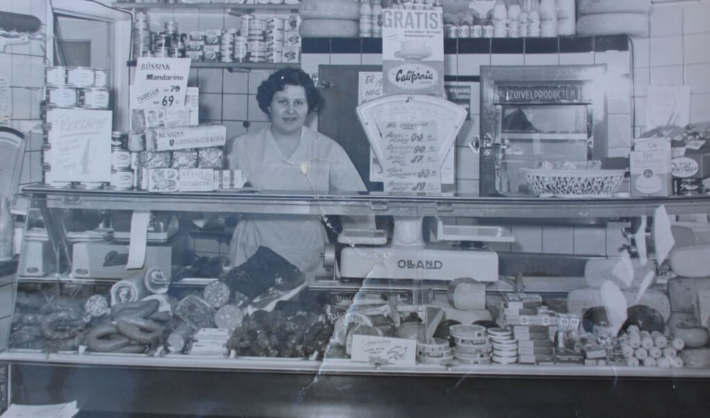 Vrouw Spies achter de toonbank in de eerste echte supermarkt aan de Herenstraat in Rhenen. 