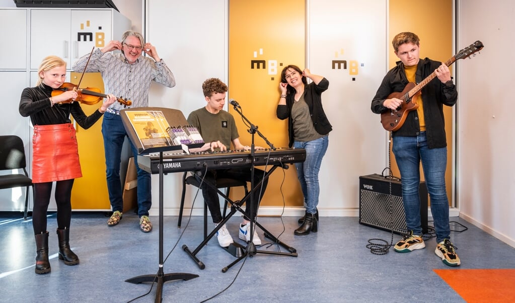 ,,Kan het zachter?'' Op de foto van links naar rechts: Hannah (viool), directeur Ferdi Schukking, Daniël (zang/keyboard), docent Gaby Kaihatu en Lars (gitaar).
