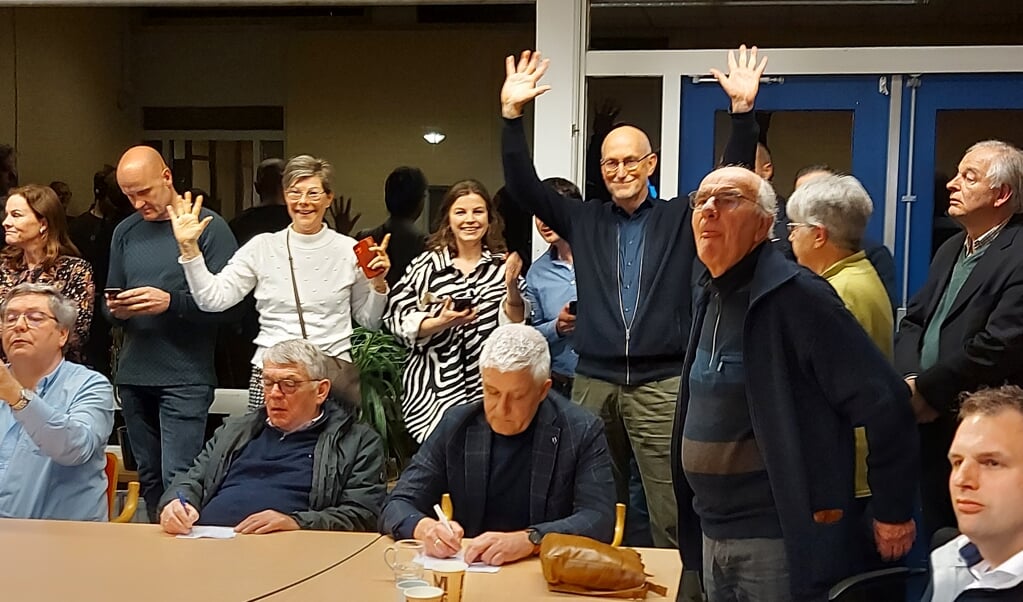 Kees Eskes steekt zijn armen in de lucht op het moment dat de uitslag bekendgemaakt wordt. Voor hem schrijft Henk van der Schoor (SGP), eveneens winnaar in Renswoude, mee.