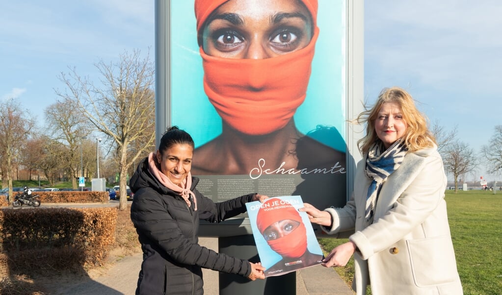 Sameena biedt burgemeester Melissant de speciale fotokrant aan waarin de foto's en verhalen van de expositie te lezen zijn 