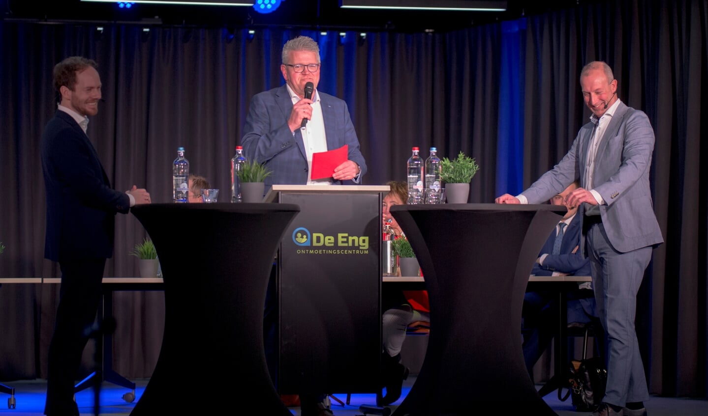 Daan de Vries (CDA) en Theo Bos (VVD) in gesprek over de hondenbelasting. Tussen hen in debatleider Riekelt Pasterkamp. 