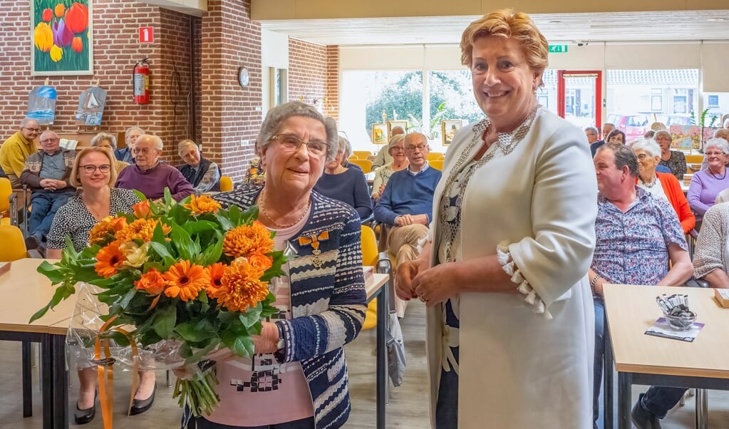 Adrie Paters-Voskuil (links) blij verrast door de benoeming tot Lid in de Orde van Oranje Nassau uit handen van burgemeester Dorine Burmanje.