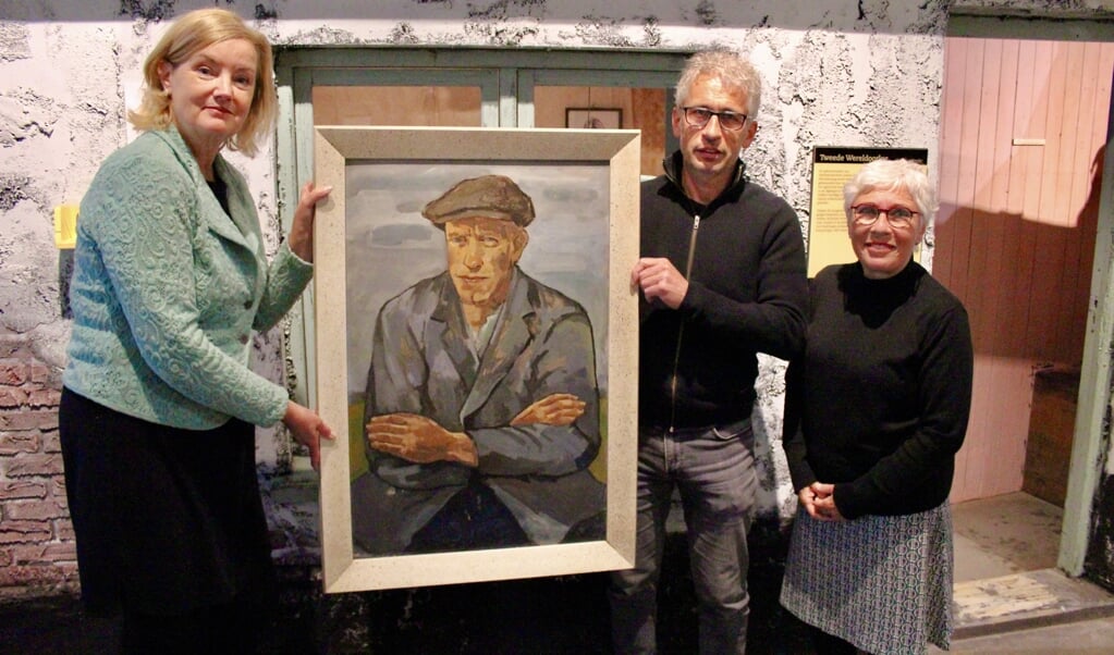 Elise van Melis ontvangt van de kinderen van Freddy Deen, Frans en Martine, het portret van Willem Boogaard. 