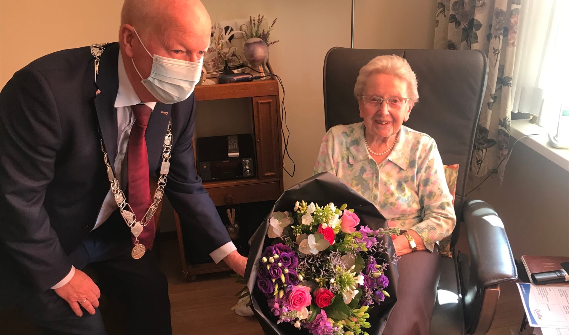 Burgemeester van Bennekom overhandigt de 100 jarige Mevr. van der Linden een prachtig boeket. 