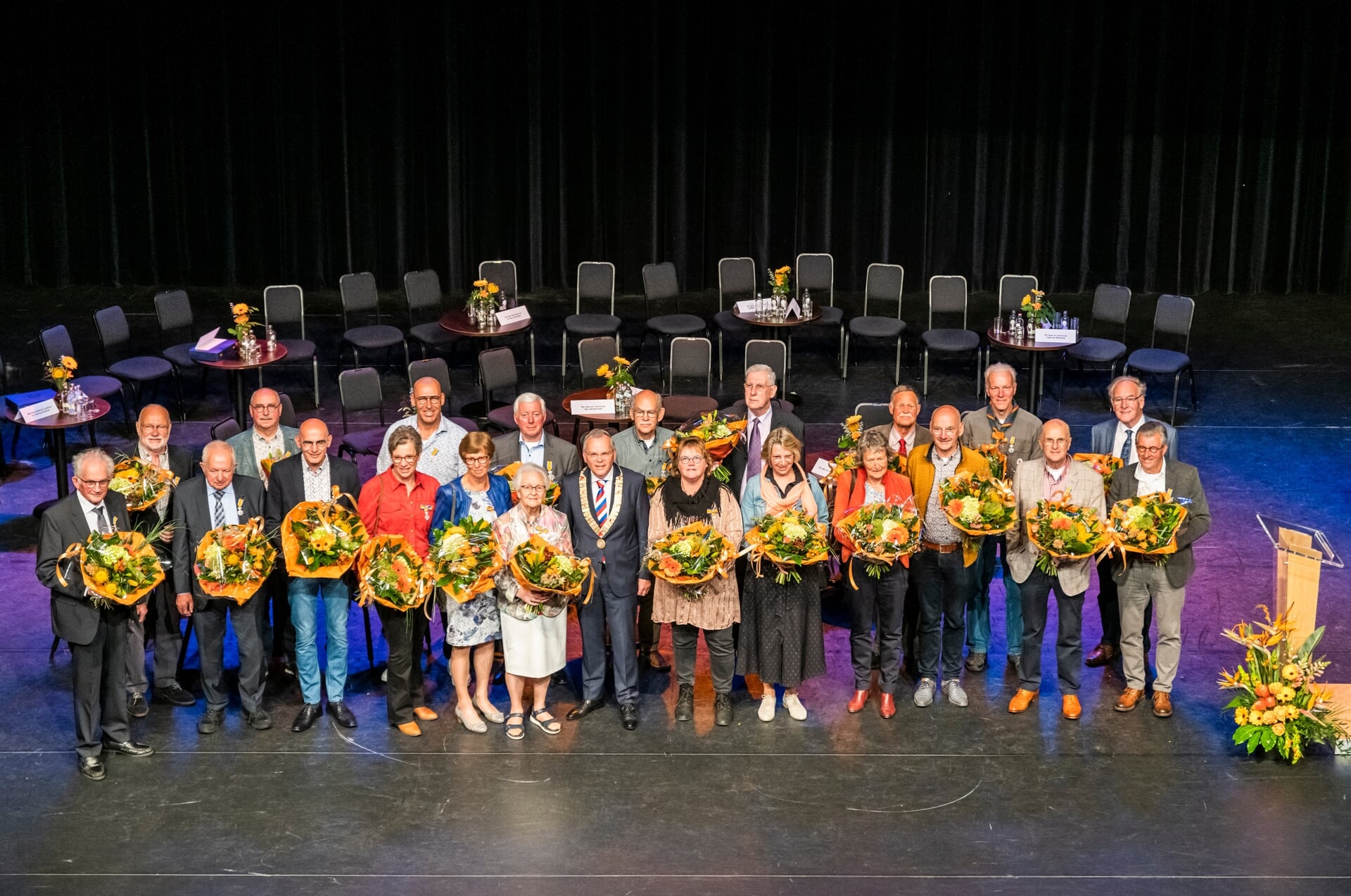 Eenentwintig gedecoreerden met de burgemeester in het Schaffelaartheater. Lukas Scheijgrond ontbreekt op de foto.