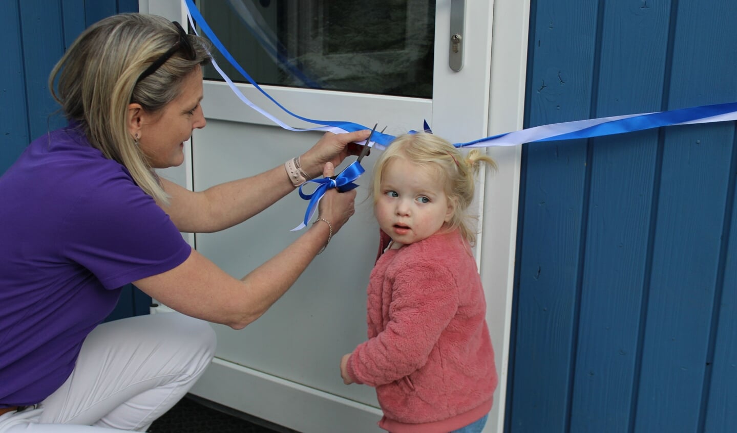 Samen met een medewerker van het Wilhelmina Ziekenhuis knipte Evi het lint van ‘De Blauwe Hut’ wat de officiële opening betekende.