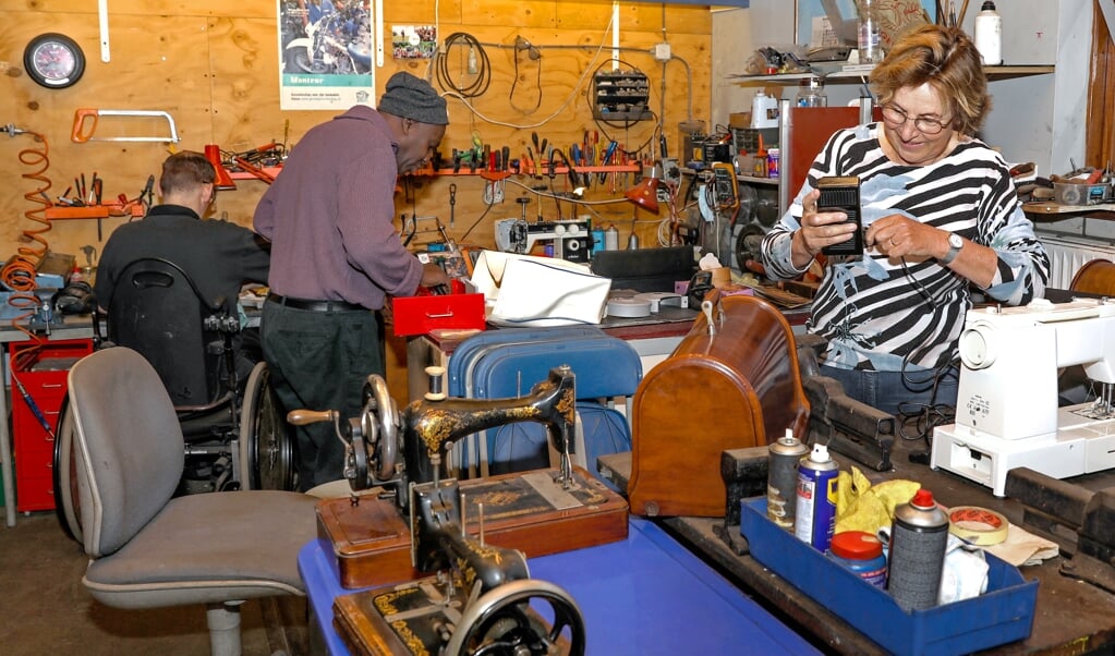 Voorzitter en vrijwilliger Lize van den Hoogenband repareert elektrische- en handnaaimachines.