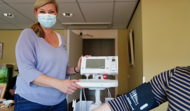 <p>Projectleider digitale innovatie Aukje Mesken van Brentano bij de Vital Signs Monitor. De uitslagen worden meteen gekoppeld aan de QR-code van de cliënt. </p>