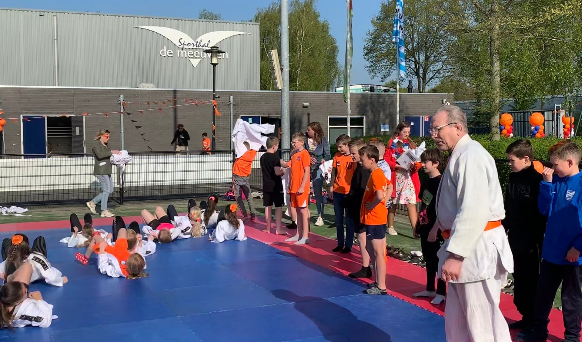 Nico Herbert geeft instructies op de judomat aan basisschoolleerlingen uit Putten.