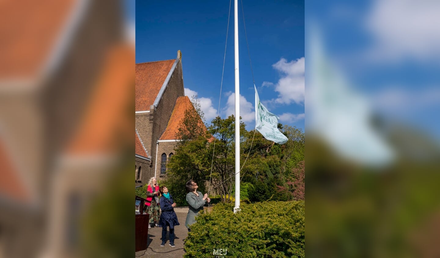Wethouder Astrid Janssen hijst de vlag bij de opening van Land Art-tentoonstelling 'Stille Omgang'