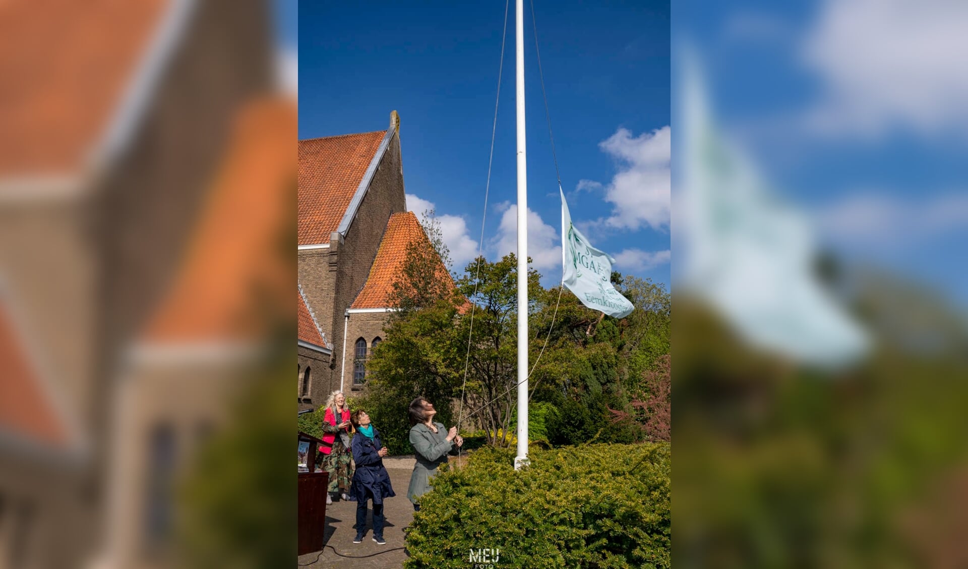 Wethouder Astrid Janssen hijst de vlag bij de opening van Land Art-tentoonstelling 'Stille Omgang' 