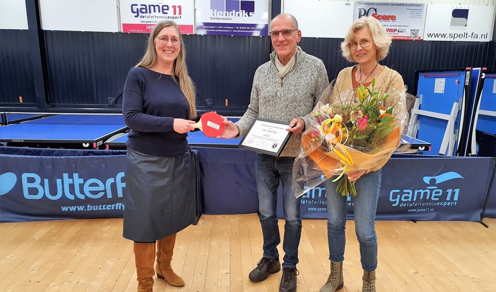 Voorzitter Annette Pancras overhandigd Lid van Verdienste Ton Smaling het jubileumbadje. Rechts zijn vrouw Nelienke.