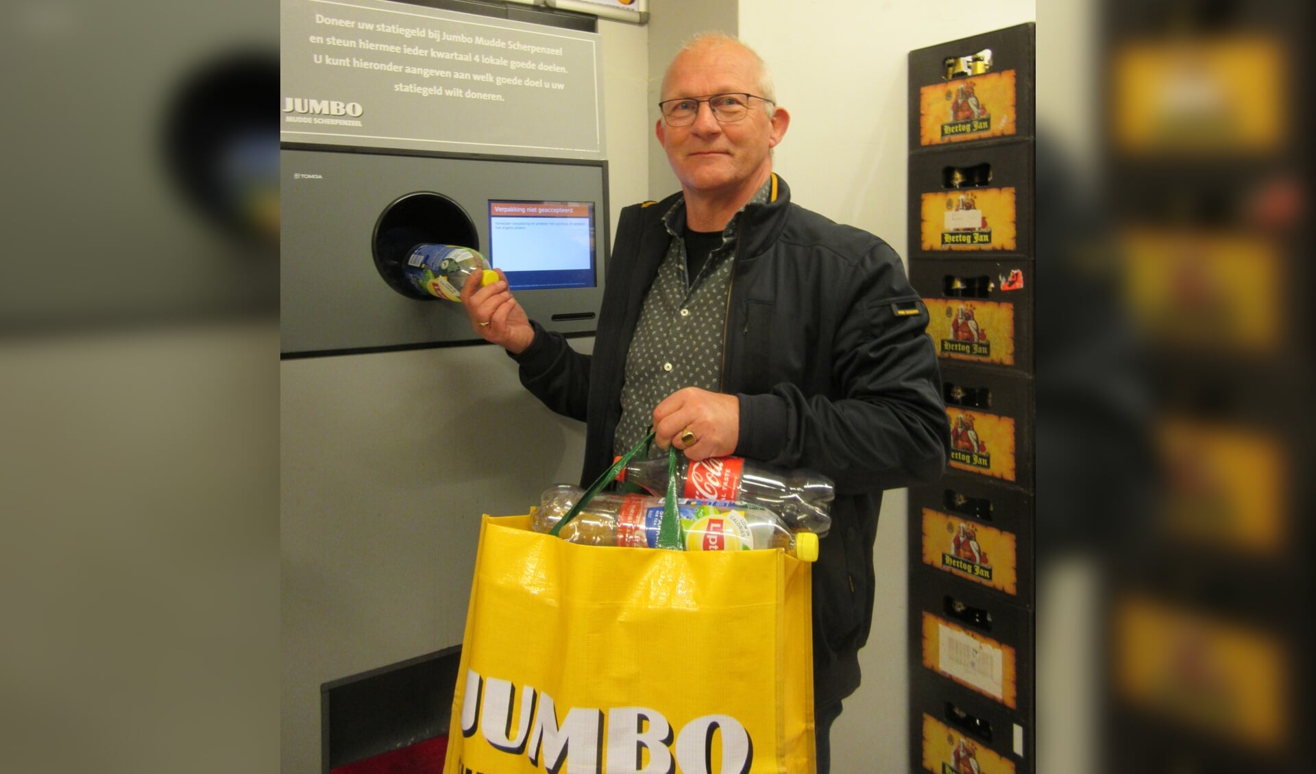 Voorzitter Ad Verbeek van de Avondvierdaagse Scherpenzeel geeft het goede voorbeeld. Hij levert lege flessen in bij het flessen-inleverautomaat in de Jumbo en doneert het statiegeld daarna aan het wandelfestijn..