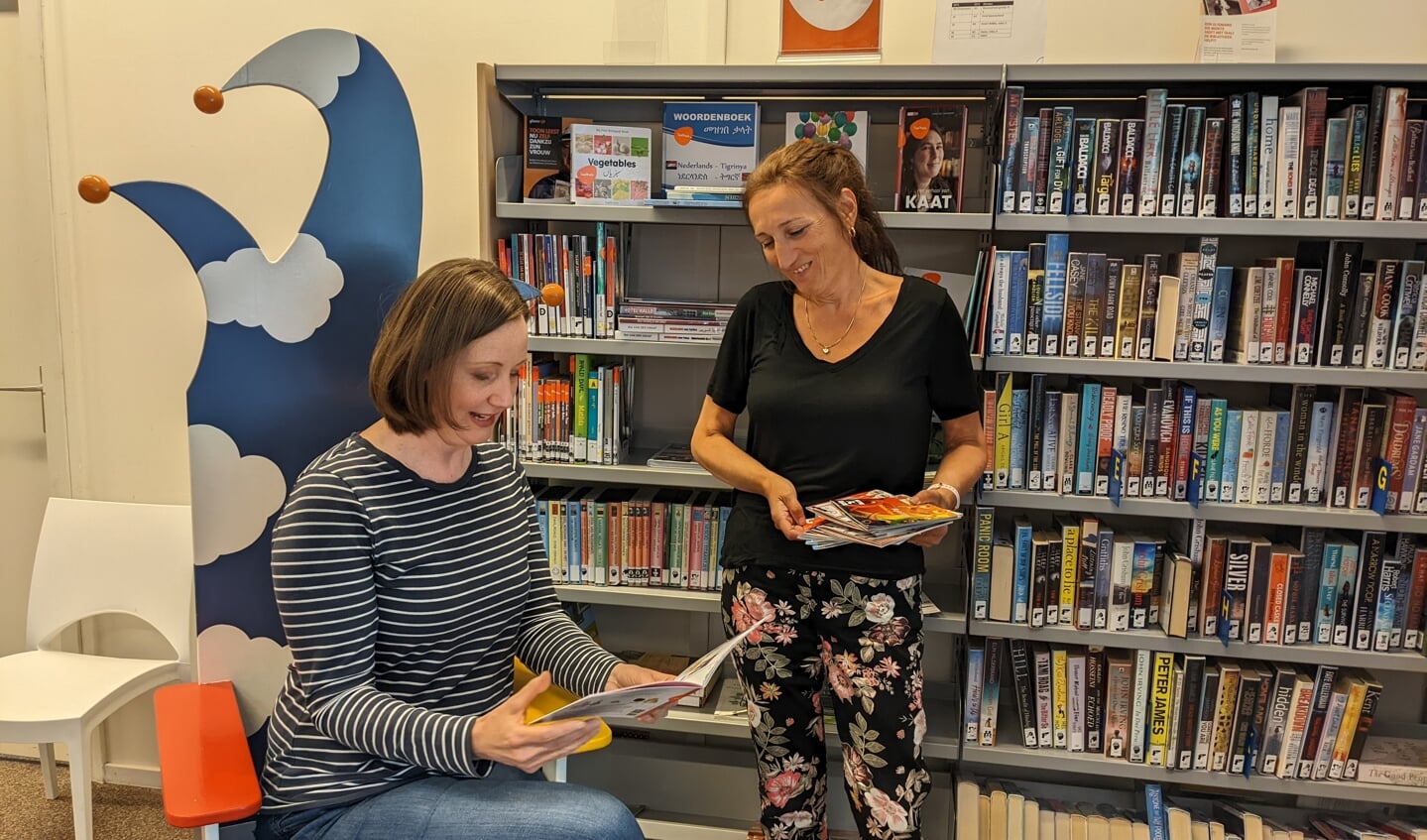 Hester Wiersma en Marja Eestermans bekijken de boekjes voor Oekraïense kinderen.