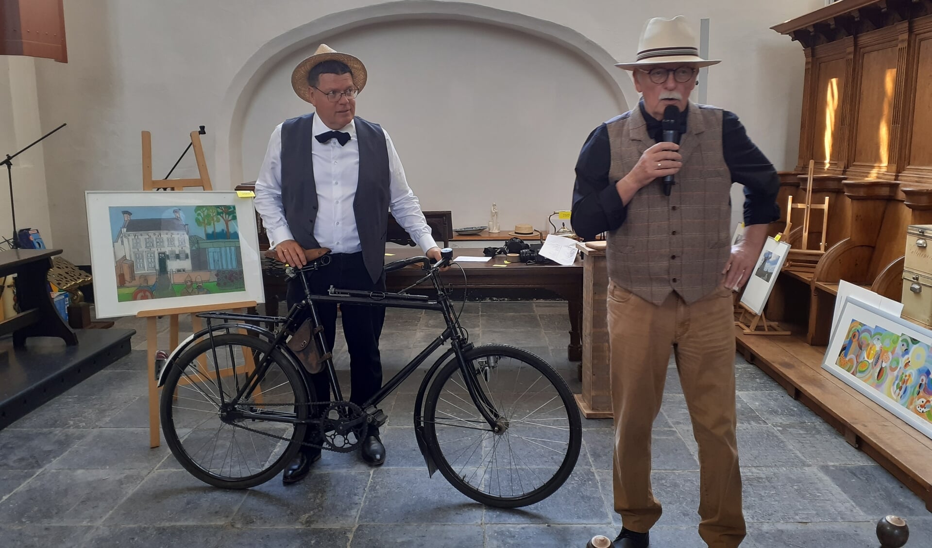 Veilingmeester Guus Swillens (r) biedt de bijzondere fiets aan