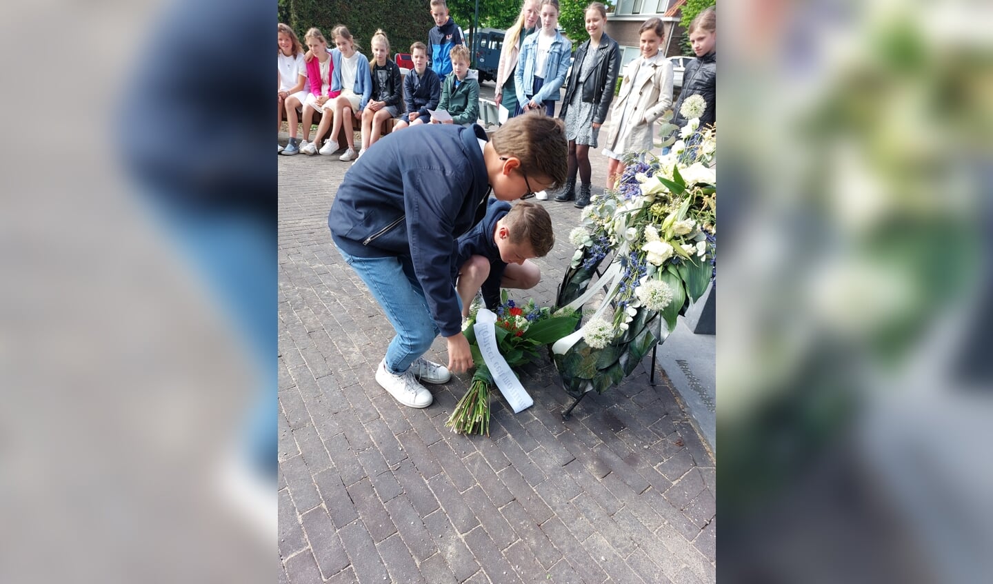 Steyn en Jair leggen een bloemstuk neer bij het monument van de Merwedegijzelaars