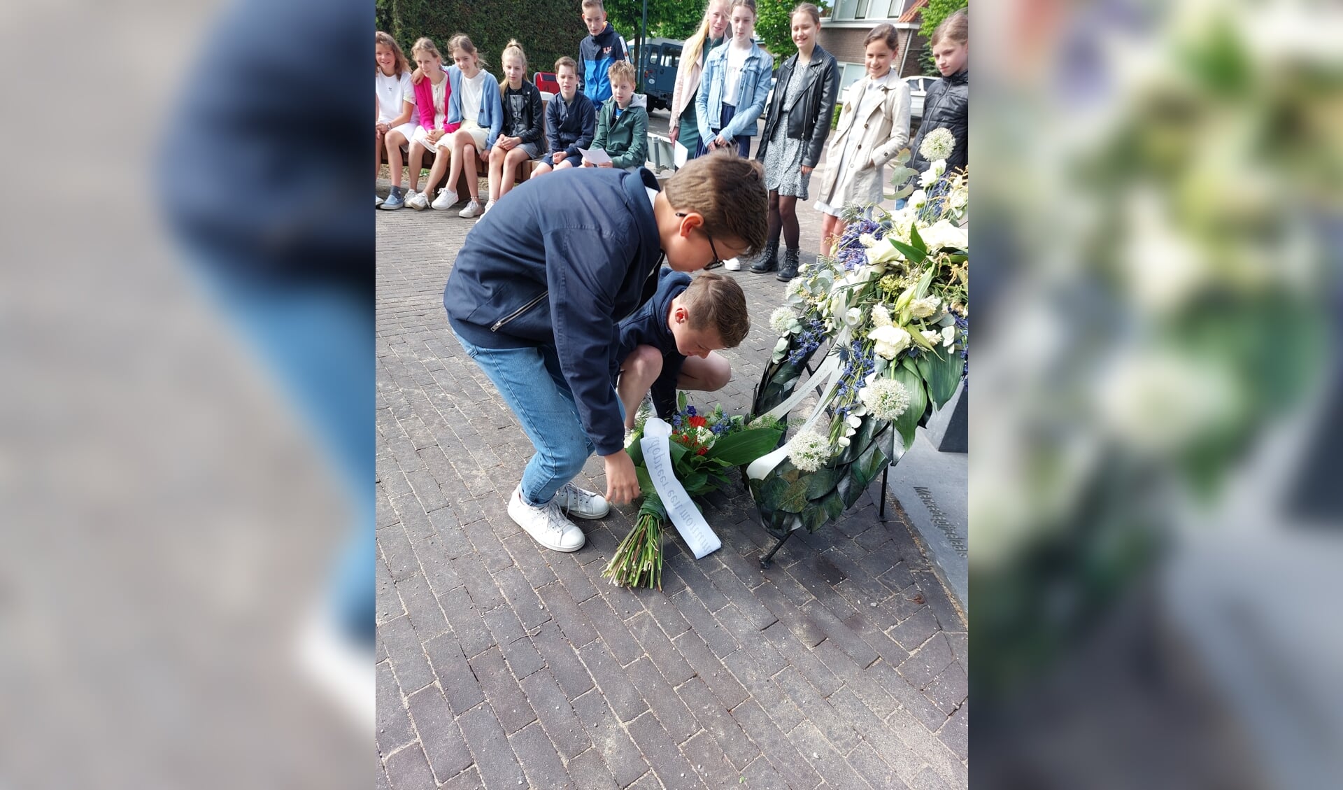 Steyn en Jair leggen een bloemstuk neer bij het monument van de Merwedegijzelaars