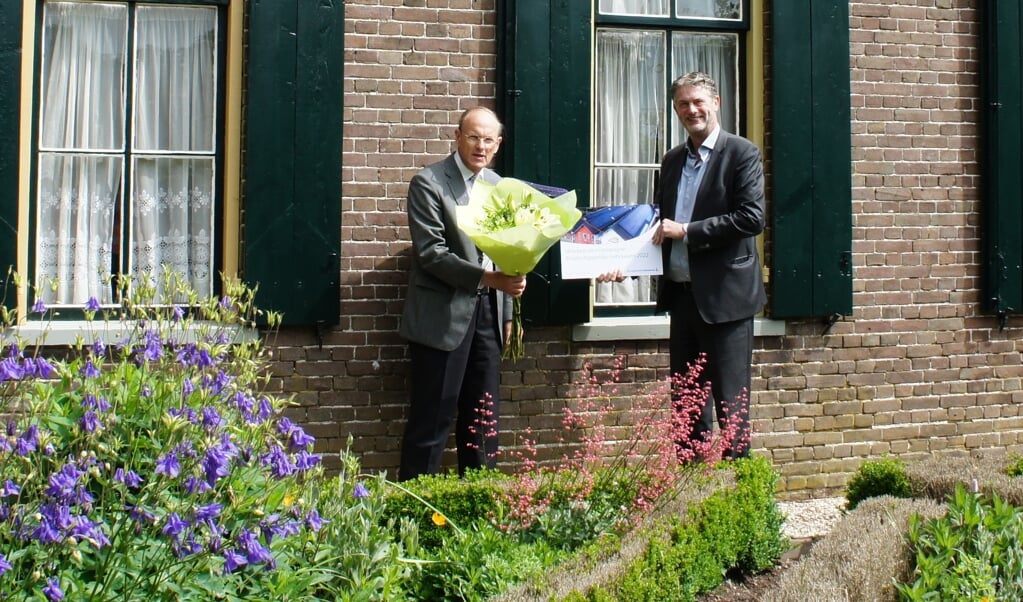 Voorzitter Jan van den Hoorn krijgt van Rabobankdirecteur Willem de Feijter een cheque voor zonnepanelen