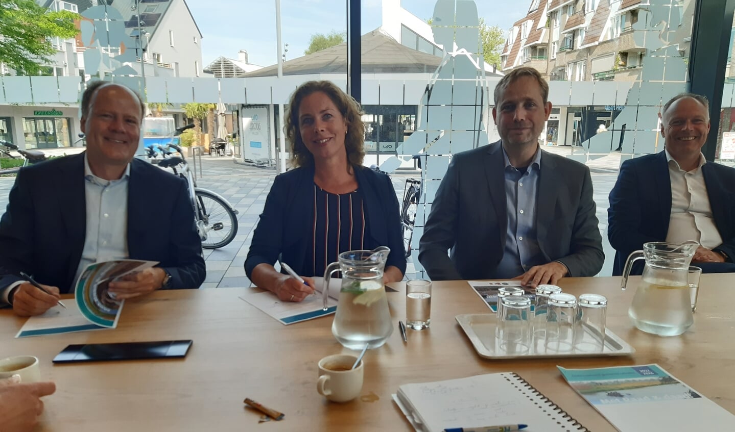 Carlos Genders (VVD), Alexandra Kolkman (Lokaal Belangrijk) en Bas van Os (CDA) zetten hun handtekening onder het coalitie-akkoord. Beoogd wethouder Patrick Kiel kijkt breed lachend toe.